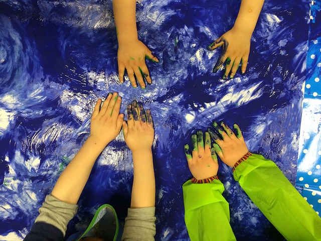Children's hands in blue finger paint